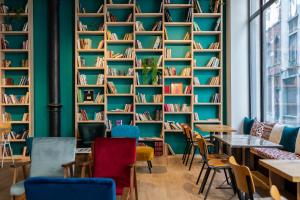 een kamer met stoelen en boekenplanken bij Aris Grand Place Hotel in Brussel