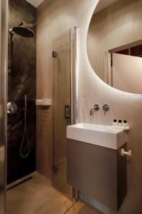 La salle de bains est pourvue d'un lavabo et d'une douche. dans l'établissement Apartament Olimpijska 116, à Olsztyn