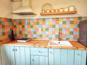 a kitchen with a sink and colorful tiles on the wall at La sat - Blândă Mărie in Bertea +22 photos
