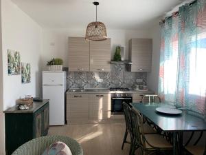 uma cozinha com uma mesa e uma sala de jantar em Appartamenti a 50 m dal mare da Cecimia's Holiday em Olbia