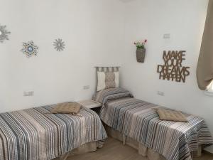 duas camas num quarto com lençóis listrados em Appartamenti a 50 m dal mare da Cecimia's Holiday em Olbia