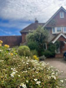 a house with a bunch of flowers in front of it at Stonehenge Hostel - YHA Affliated in Amesbury