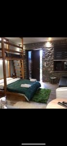 a bedroom with two bunk beds and a stone wall at ΧΑΡΟΥΛΑ STUDIO in Pavliani