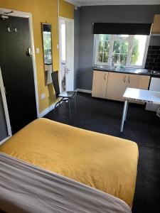 a room with a bed and a table and a kitchen at Hatfield SAVE-MONEY Rooms - 10over10 for PRICE! in Hatfield