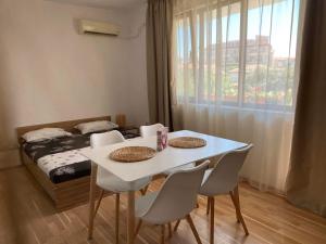 a room with a table and chairs and a bed at Петрови in Chernomorets