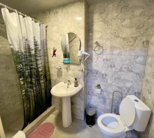 een badkamer met een wastafel, een toilet en een douche bij Hotel Maria in Tbilisi City
