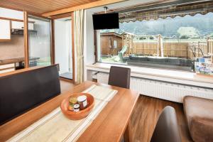 ein Esszimmer mit einem Tisch und einem großen Fenster in der Unterkunft Apartment Hohe Tauern in Bramberg am Wildkogel