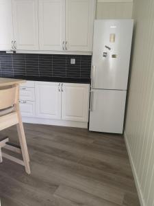 een keuken met witte kasten en een witte koelkast bij New 2 bed room apartment in Halden in Halden