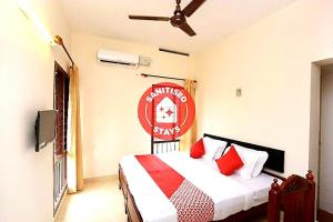 a bedroom with a bed with a red sign on the wall at Hotel Sunday - Townhouse Club Airport Trivandrum in Trivandrum