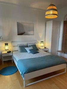 1 dormitorio con 1 cama grande con almohadas azules en Appartement de charme dans maison de maître bruxelloise en Bruselas