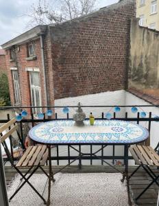 una mesa en un patio con 2 sillas en Appartement de charme dans maison de maître bruxelloise en Bruselas