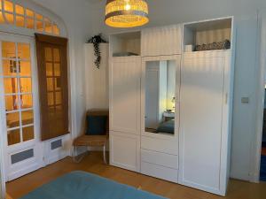 ブリュッセルにあるAppartement de charme dans maison de maître bruxelloiseの白い大型クローゼット(椅子付)が備わる客室です。