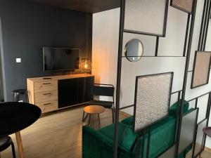 a living room with a green couch and a television at Apartament 87 in Szczecin