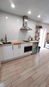 a kitchen with white cabinets and a wooden floor at Cala Nova Studios, Vinaròs in Vinarós +28 photos