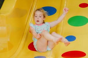 a little girl is playing on a slide at Stonehenge Hostel - YHA Affliated in Amesbury