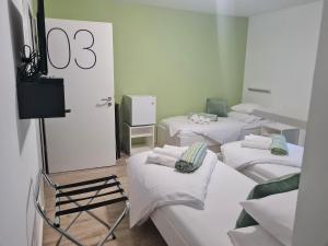 pokój z 4 łóżkami i białą pościelą w obiekcie AZUR ROOMS LJUBLJANA w Lublanie