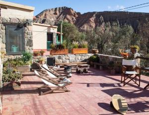 een patio met stoelen en tafels en een berg bij Hostal de Altura in Tilcara