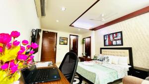 una camera con un letto e un computer portatile su un tavolo di BluO Cozy Studio with Balcony - Green Park HKV a Nuova Delhi