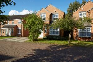 a brick house with two trees in front of it at HAVEN HOUSE DETACHED Residence in Headingley