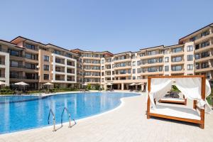 a hotel swimming pool with a canopy bed in front of a building at Sea Dreams Apartment in Sveti Vlas
