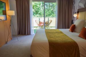 a hotel room with a bed and a sliding glass door at Quintessia in Orvault