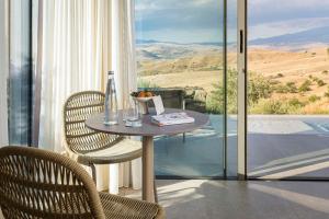 una mesa y sillas en una habitación con vistas en Rocca dei Saraceni, en Regalbuto