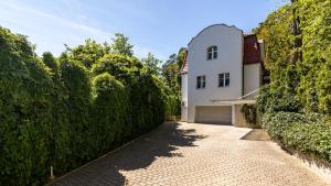 een oprit die leidt naar een wit huis met een garage bij VENTI Apartments Willa Sopot in Sopot