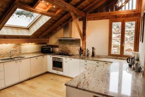 Una cocina con gabinetes blancos y una ventana grande. en ALP INN, en Morzine