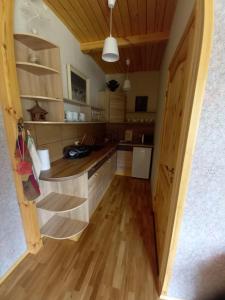 a kitchen with wooden counters and a wooden floor at Rūnēnu zāļu namiņš in Vidzeme