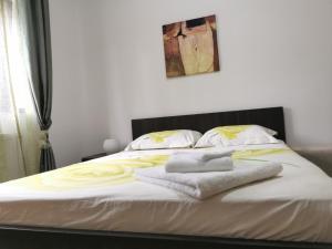 - un lit avec des serviettes assises au-dessus dans l'établissement Apartament Ovidiu, à Giroc