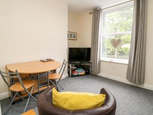 una sala de estar con una mesa y una silla en The Pebbles, en Hornsea