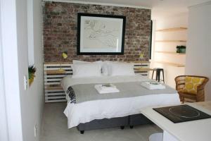 1 dormitorio con 1 cama grande y pared de ladrillo en No. 9 Keurboom, en Ciudad del Cabo