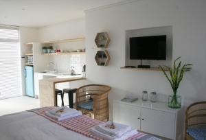 Cape Town的住宿－No. 9 Keurboom，卧室配有一张床,墙上配有电视。