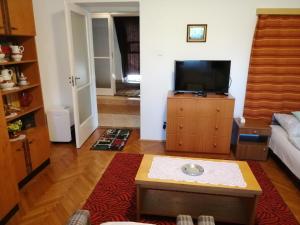 a living room with a flat screen tv on a dresser at Táncsics magánszállás Pécs in Pécs