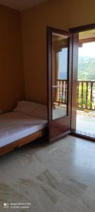 a bedroom with a bed and a sliding glass door at Best view in Polychrono - Families Only in Polychrono
