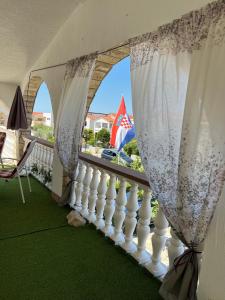 balkon z białą poręczą i oknem w obiekcie Apartman Tunja w mieście Vir