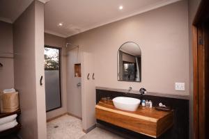 a bathroom with a sink and a mirror at Toshari Lodge in Okaukuejo