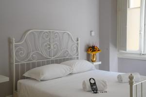 un letto bianco con testiera in argento e cuscini bianchi di Affittacamere ALBA a Firenze