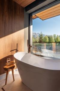 a bath tub in a bathroom with a large window at Villa T Apartments & SPA in Zakopane