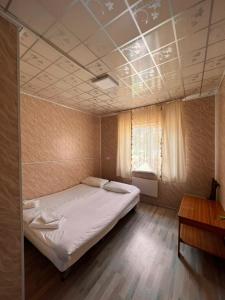 a bedroom with a large bed and a window at Guest House Jamal in Naryn