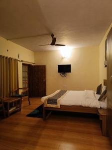 a bedroom with a bed and a flat screen tv at The Woods in Nainital