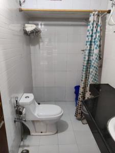 een witte badkamer met een toilet en een wastafel bij The Woods in Nainital