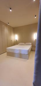 a bedroom with a bed with two lights on it at Ammos ikia in Ouranoupoli