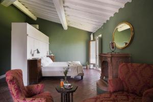 una camera con letto, sedia e specchio di Le Farnete a Carmignano