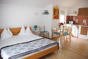 1 dormitorio con 1 cama y cocina con mesa en Apartments Gavric, en Trogir