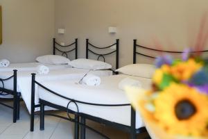 Un grupo de 4 camas en una habitación en Affittacamere ALBA en Florencia