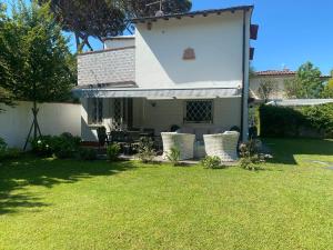 a backyard with a white house with a table and chairs at CivicoSedici in Forte dei Marmi