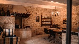 a dining room with a table in a room with stone walls at Holiday Homes Susak Sansego in Susak