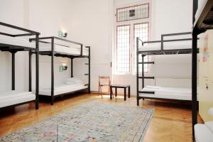 ブダペストにあるマーヴェリック ホステル & エンスイーツの二段ベッド4台とラグが備わる客室です。