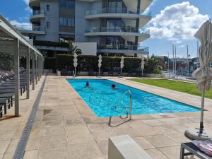 a swimming pool in front of a building at Parama 102 in Cape Town